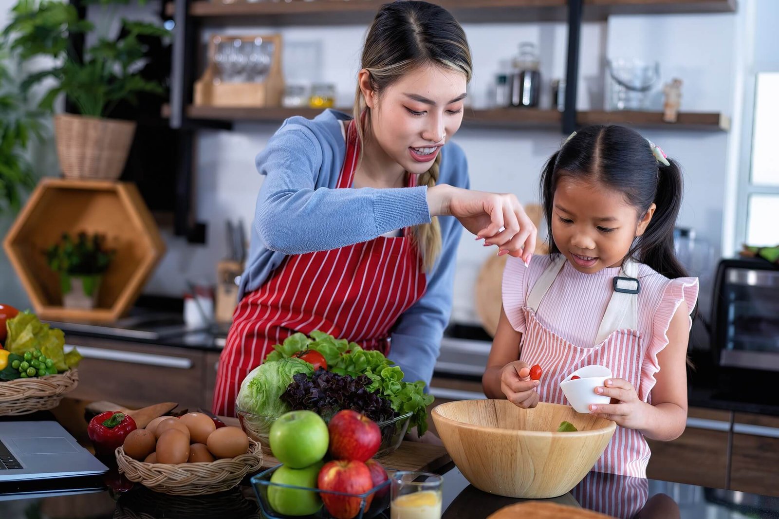 young-mother-teach-daughter-in-the-kitchen-learn-online-cooking-clean-food-from-the-laptop-computer.jpg